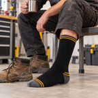 Black, grey and yellow work socks worn with work boots in a workshop