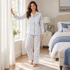 Model wearing Lamros blue floral long-sleeve pyjamas beside a bedroom window